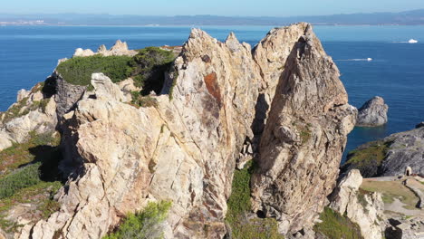 Close-aerial-shot-over-the-edge-of-Porquerolles-cap-mèdes-rocky-cliffs-France